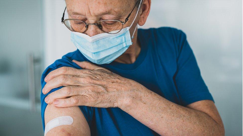 old woman looking at arm after vaccine