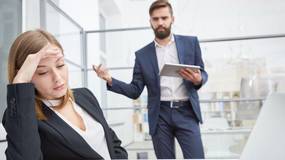 man arguing in an office with woman