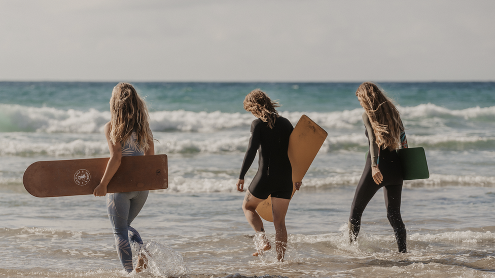 Bodyboarders going into the sea