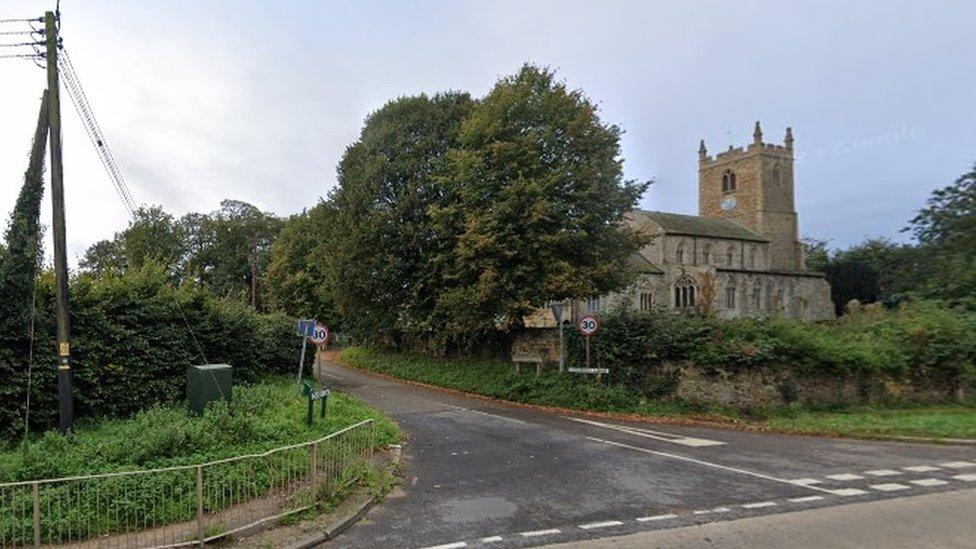 Village crossroads with church and trees