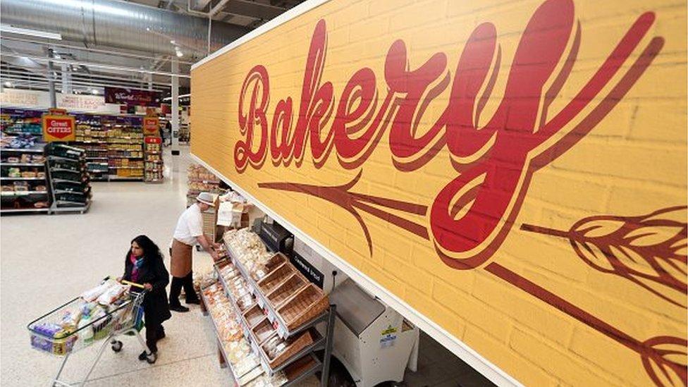 A customer passes the fresh bakery counter at a Morrisons supermarket,