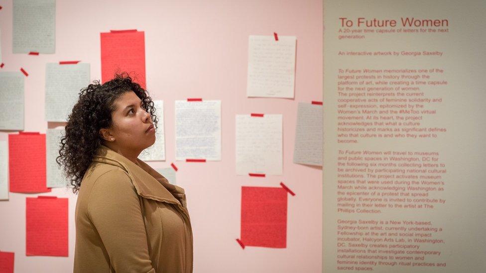 Woman looking at a wall of letters