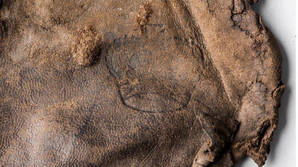 A leather pouch with crown symbols saved from the wreckage