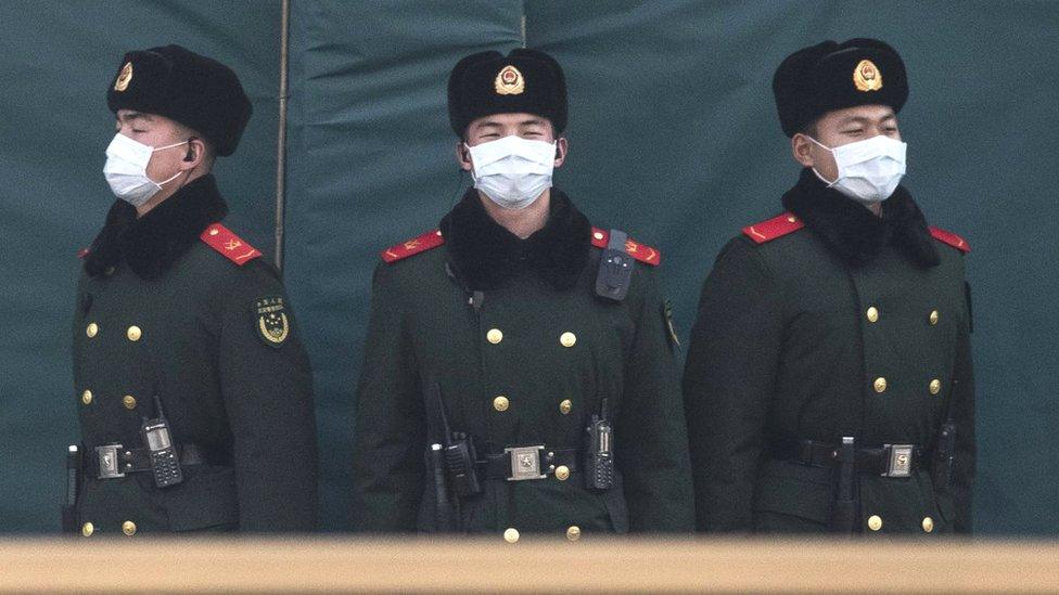 Chinese policemen wearing masks