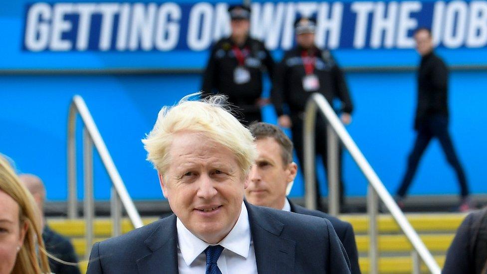 Prime Minister Boris Johnson walks through the Conservative Party annual conference venue in Manchester