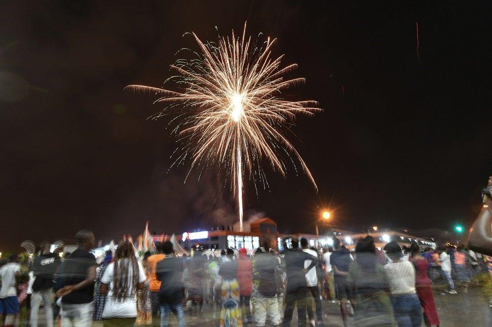 Ivorians watch a fire works display to ring in the New Year, in Koumassi a neighbourhood of Abidjan on 1 January 2021