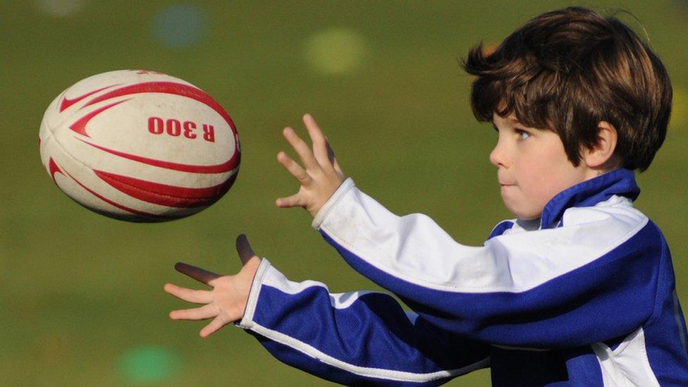 Boy catching a rugby ball