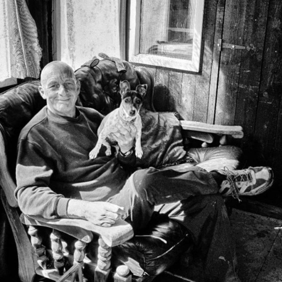 A man with his dog in a chair