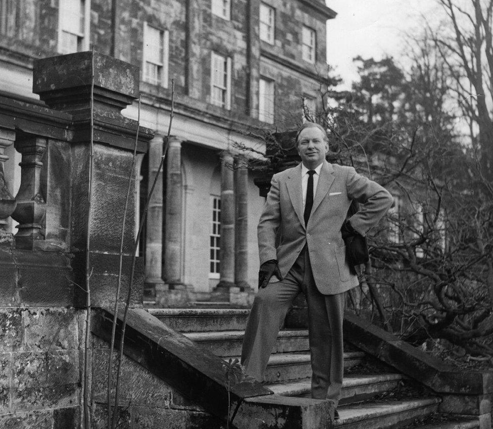 L Ron Hubbard standing outside his Church of Scientology home in East Grinstead