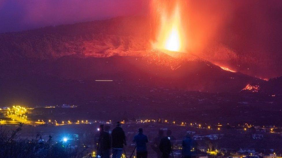 Lava and smoke can be seen rising from the volcano