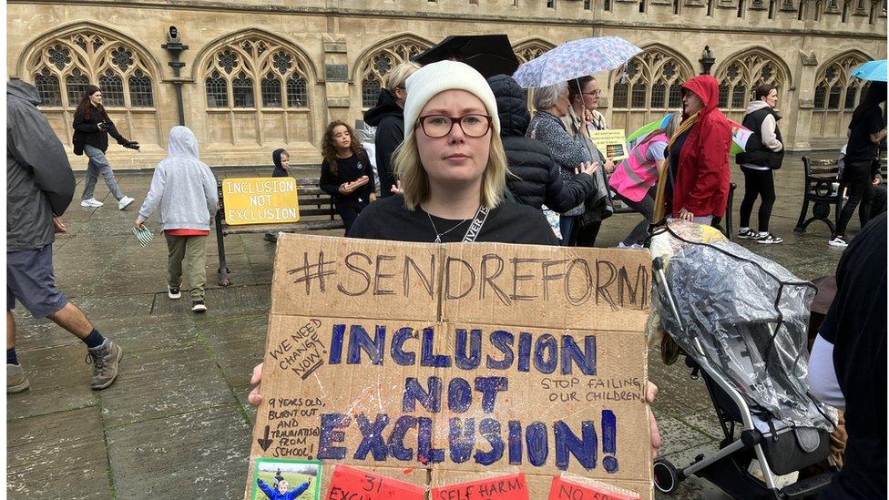 A protester holds up a placard saying "Inclusion not exclusion!" at the protest