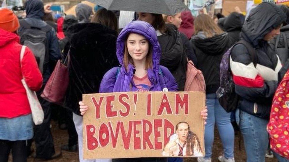 Poppy Stowell-Evans holding a placard at a protest