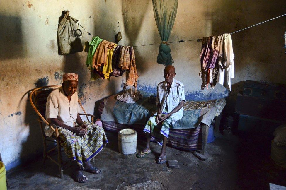 Two men sit in their house.