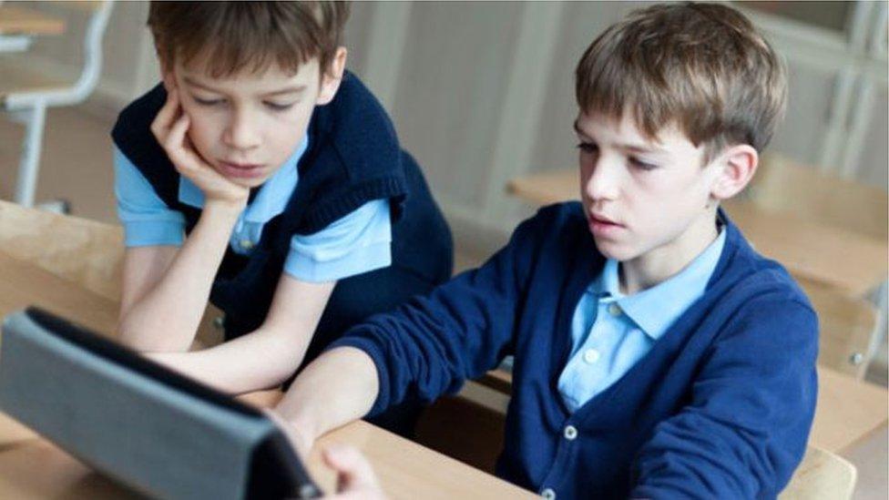 Two boys playing on an ipad