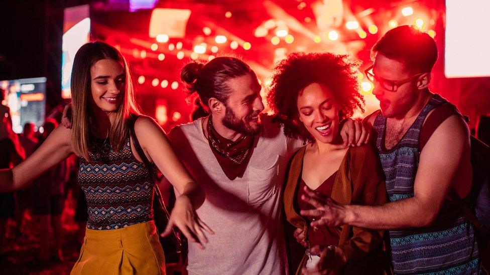 Four people at an outdoor event dancing