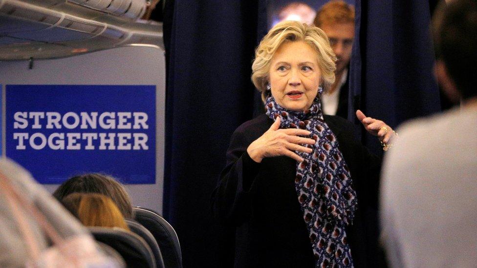 Democratic presidential nominee Hillary Clinton talks to her staff onboard her campaign plane in White Plains, New York, en route to St. Louis for the second presidential debate with U.S. Republican presidential candidate Donald Trump