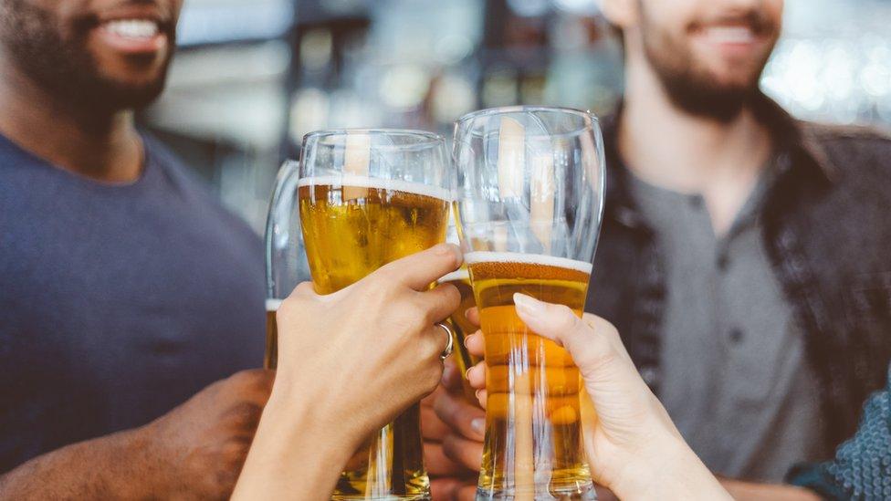 Friends toasting with beer in a pub