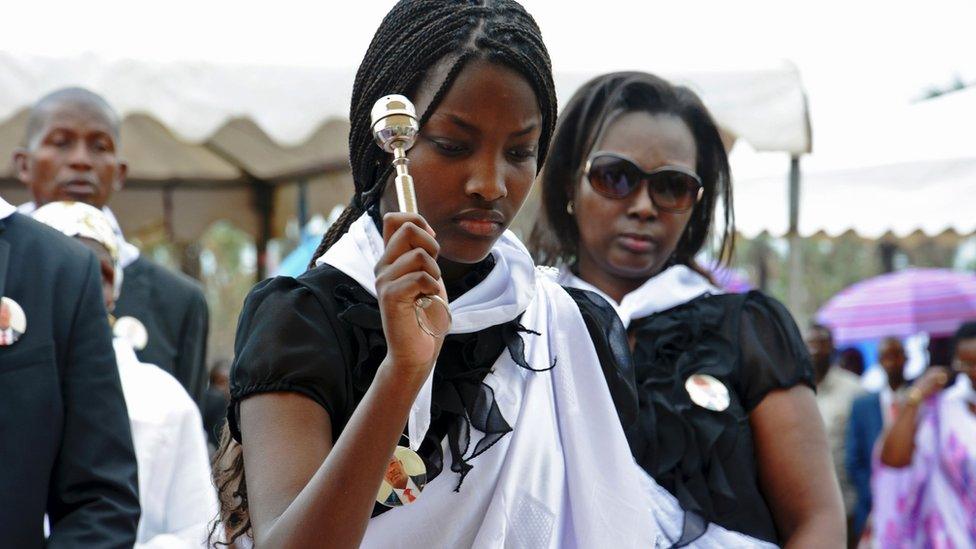 On Tuesday, 10 Jan, the daughter of slain Burundian minister of water, Emmanuel Niyonkuru, blesses his father's grave during his funeral in Bujumbura.