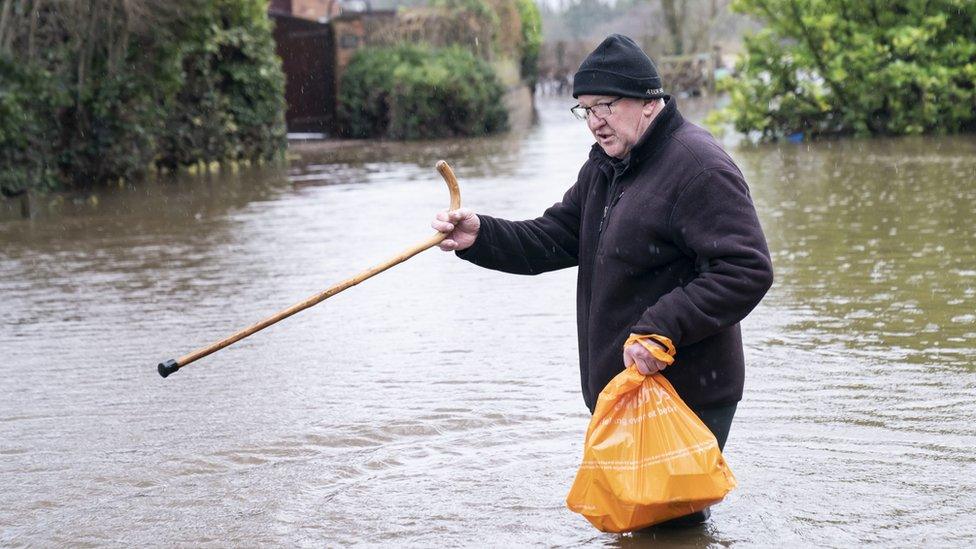 Man walks through flood water near his home in Tadcaster after the River Wharfe