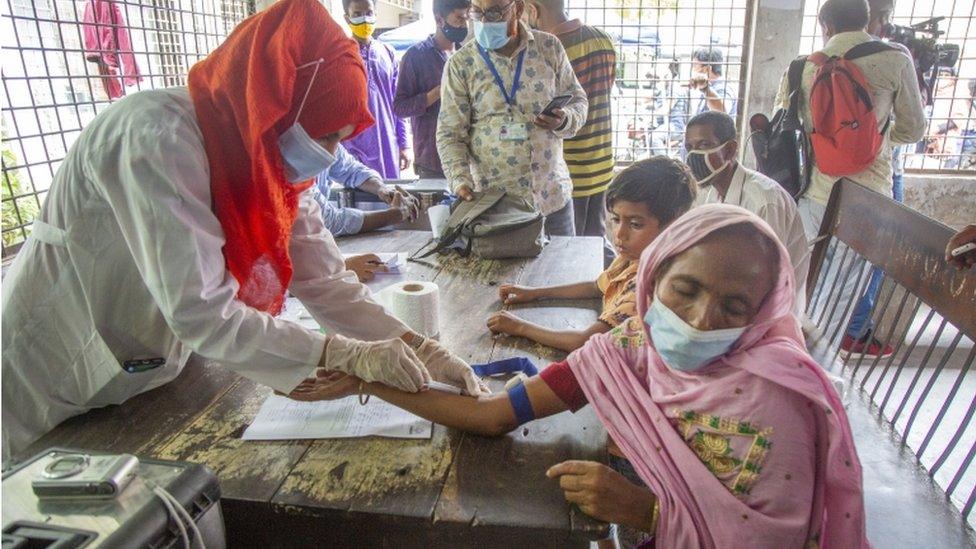 A medical officer collects blood samples from relatives of victims for DNA testing at Dhaka Medical Collage Hospital in Bangladesh, 10 July 2021