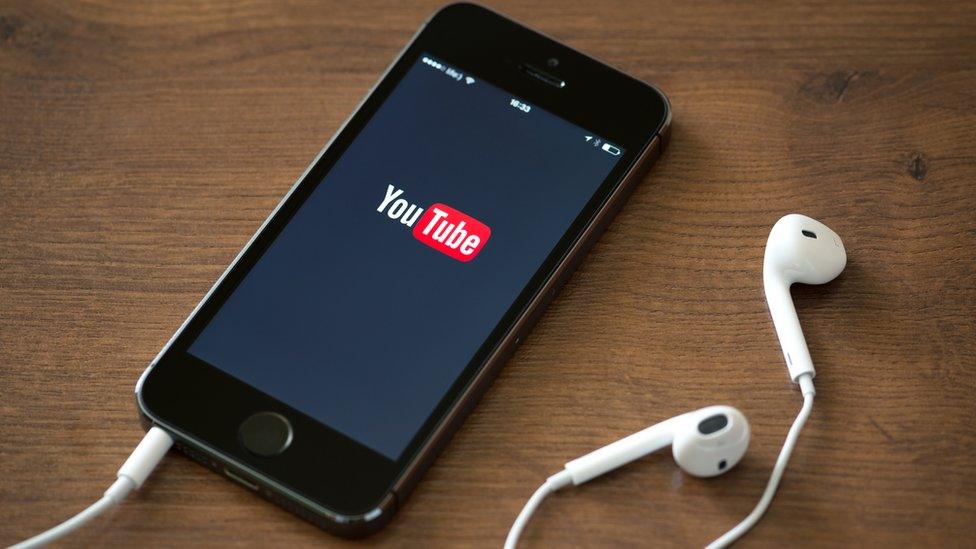 Youtube screen on a phone with headphones