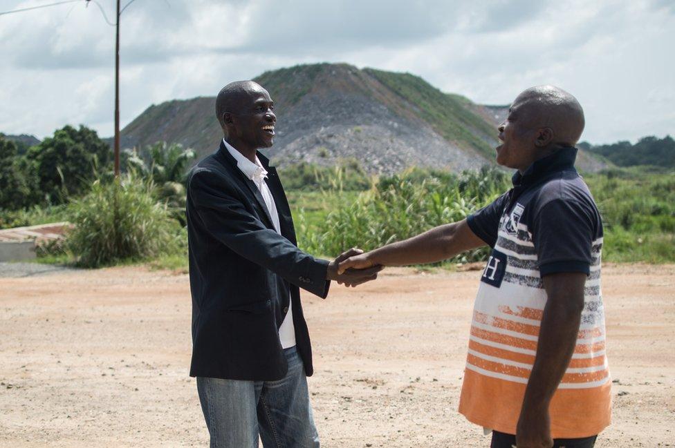 Two men shake hands with each other