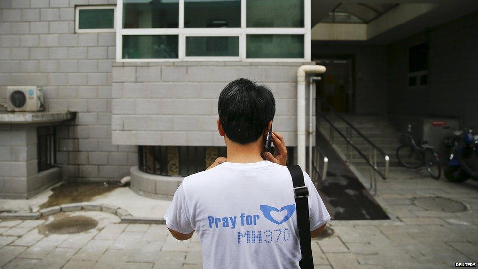 Jiang Hui, whose mother was onboard the missing Malaysia Airlines flight MH370 talks on a mobile phone after meeting reporters near his home in Beijing (30 July 2015)