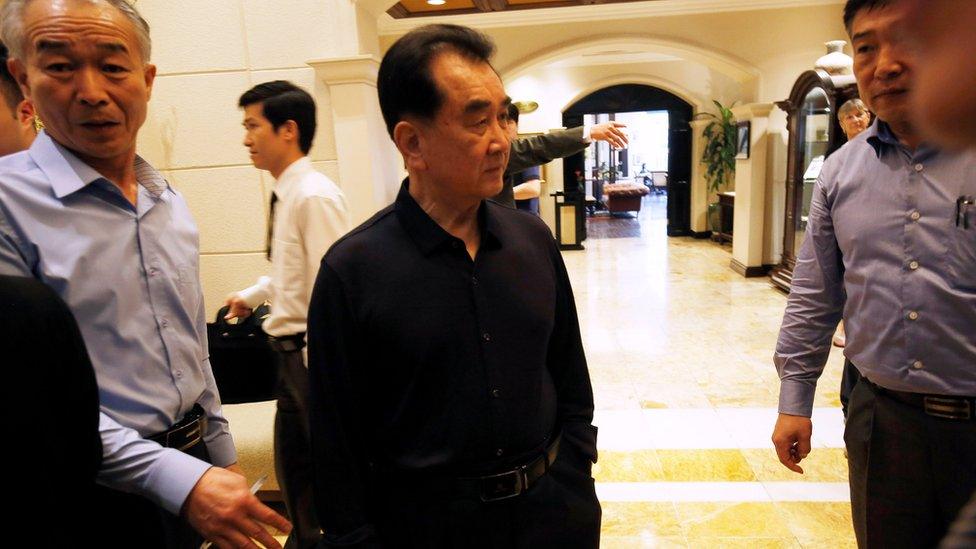 Kim Chang Son stands between his staff inside Metropole Hotel in Hanoi