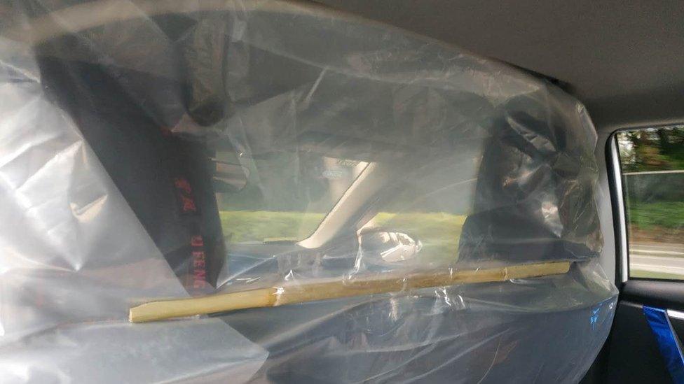 Plastic sheeting attached to car seats in a taxi