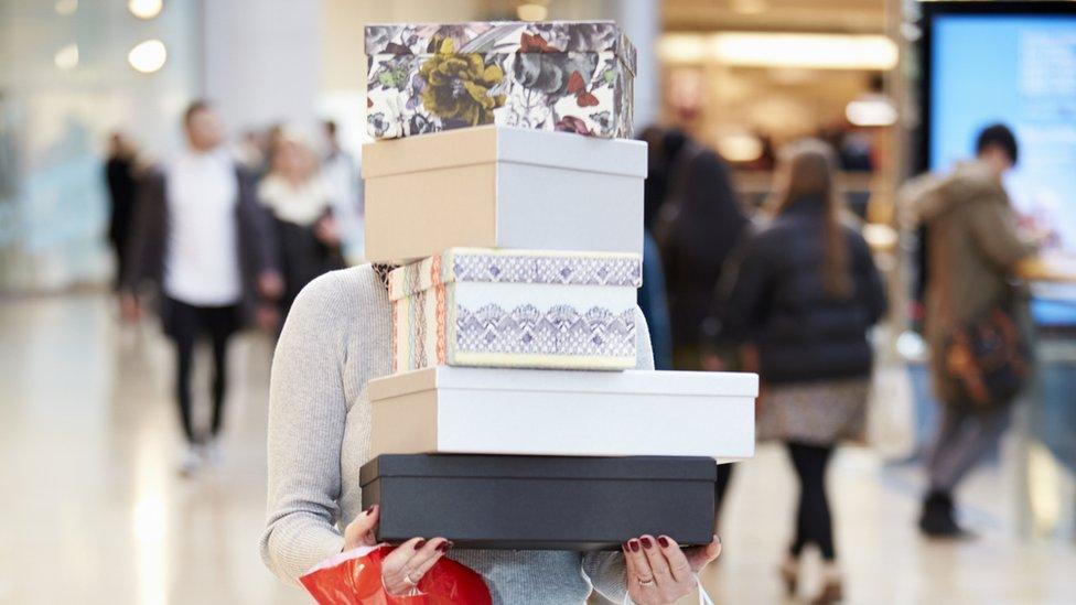 Carrying a stack of boxes and bags