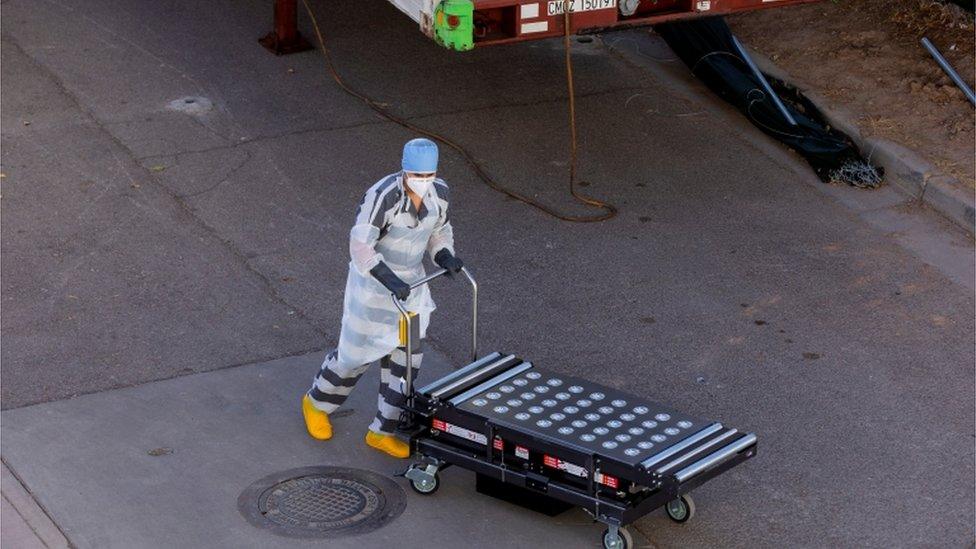 Inmate helping move bodies