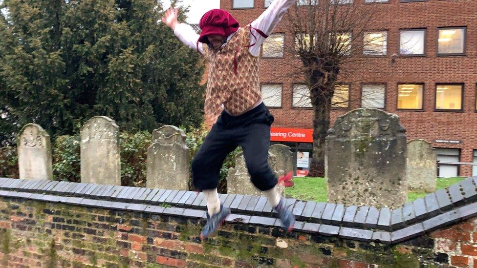 Nicholas Potts jumping the church wall at the end of his challenge near the Maddermarket Theatre in Norwich