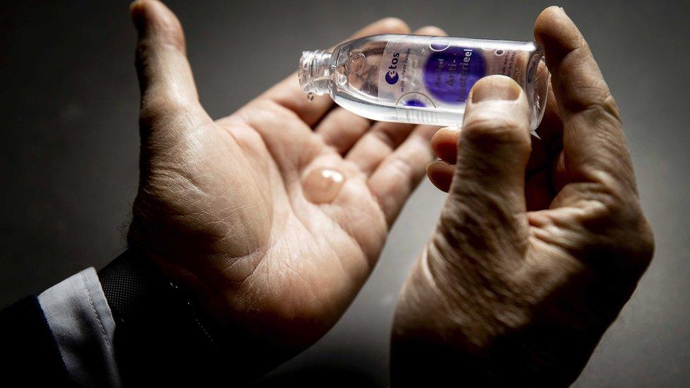 Close up of a man applying hand sanitiser