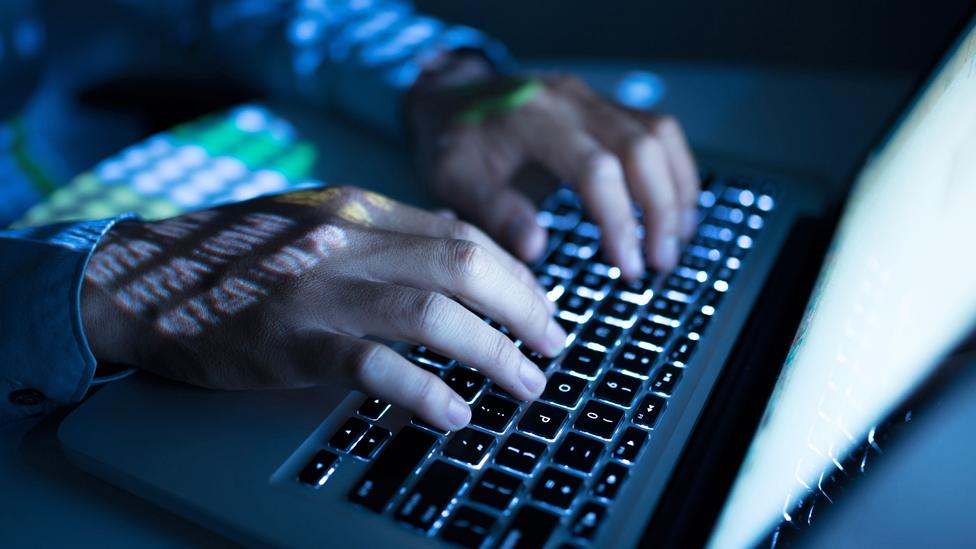 Hands typing on a laptop