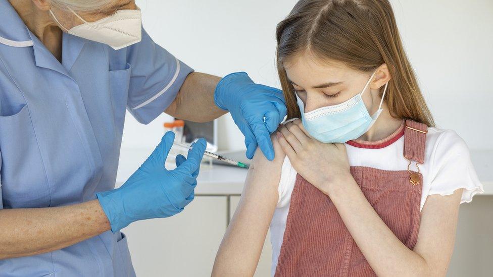 A young girl being vaccinated