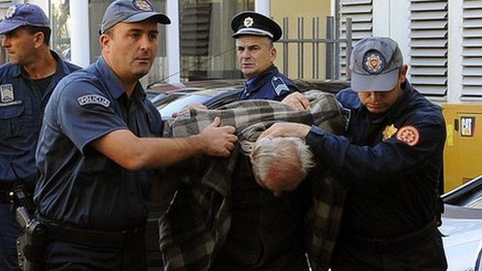 A man is escorted by Montenegrin police officers to the special court in Podgorica on October 16, 2016