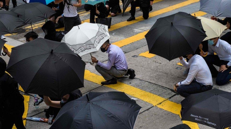 Office workers and protesters gather in Central