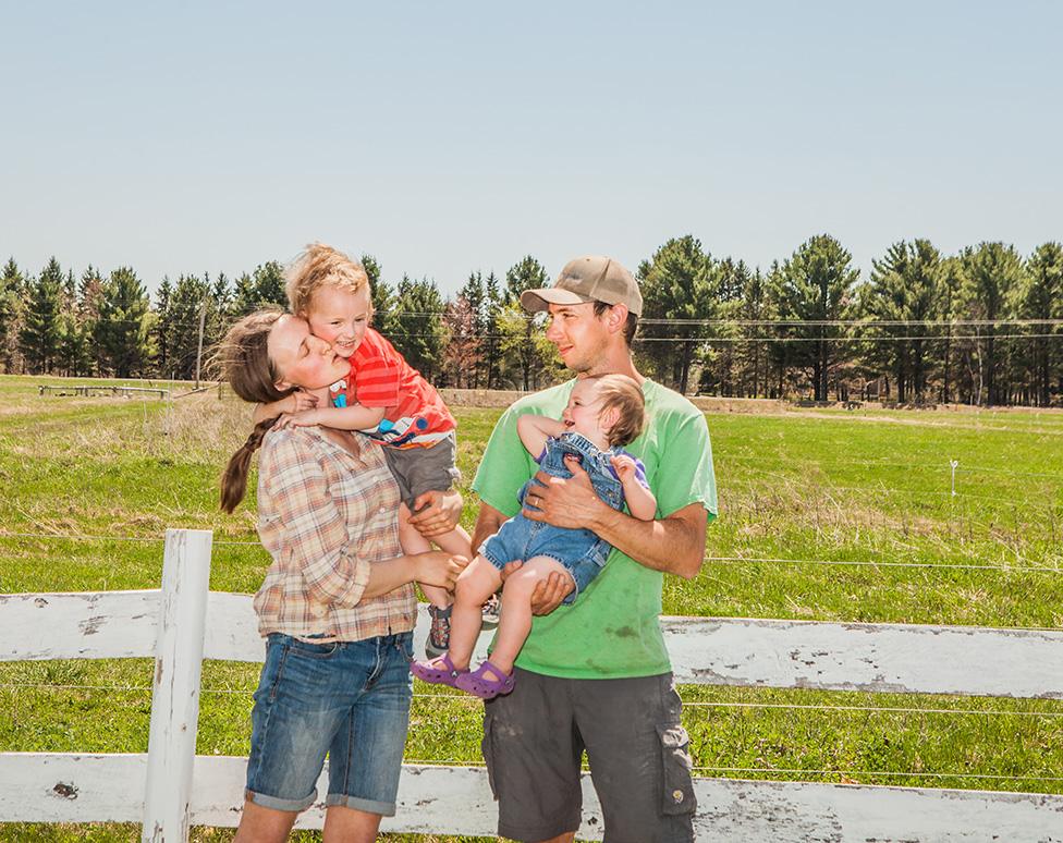 Johnson family standing outdoors against a fence