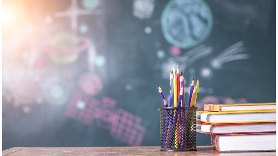 Pencils and a chalkboard in a classroom