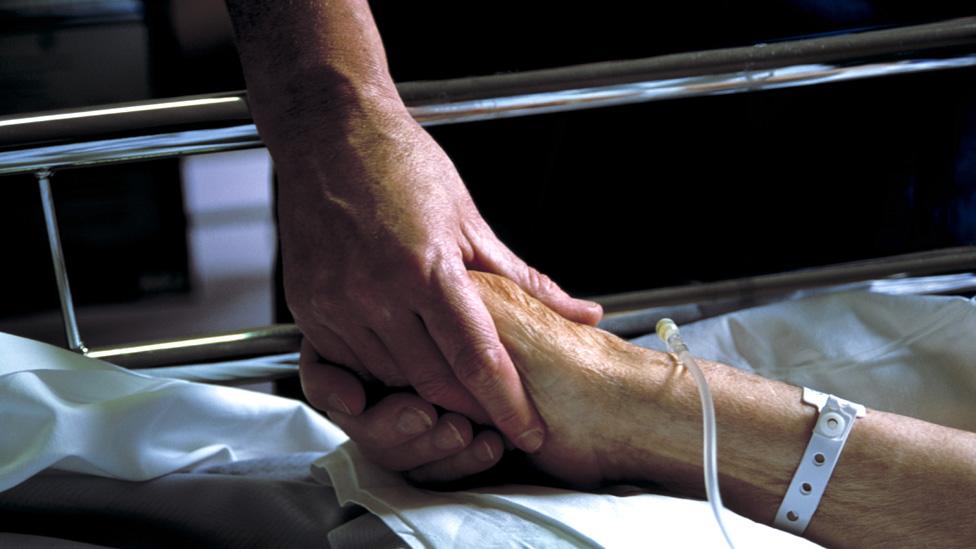 Nurse holding patient's hand