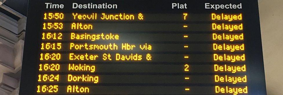 An electronic rail departures board showing all trains are "delayed"