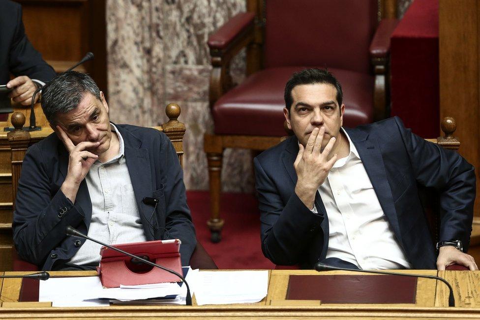 Greek Prime Minister Alexis Tsipras, right, and Finance Minister Euclid Tsakalotos, attend a parliamentary session in Athens, 22 May