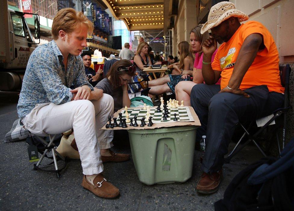 People playing chess in the queue for return tickets to Hamilton in New York in 2016