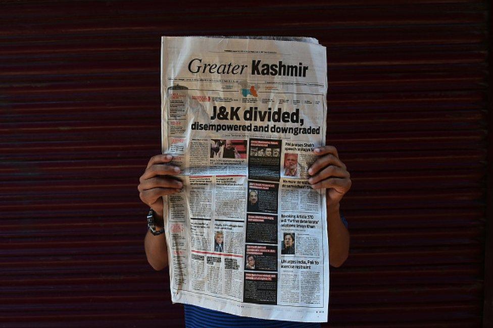 A Kashmiri boy poses with a newspaper headline &quot;J&amp;K Divided&quot; during curfew in Srinagar, Indian Administered Kashmir on 06 August 2019. Curfew Continues in Kashmir after the Scrapping of Article 370 on 06 August 2019. Curfew has been implemented across Jammu and Kashmir to thwart any protests. All the communication channels have been blocked across the valley. (Photo by Muzamil Mattoo/NurPhoto via Getty Images)