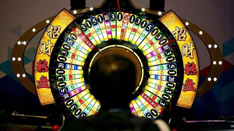 A man tries his luck at a wheel of fortune machine