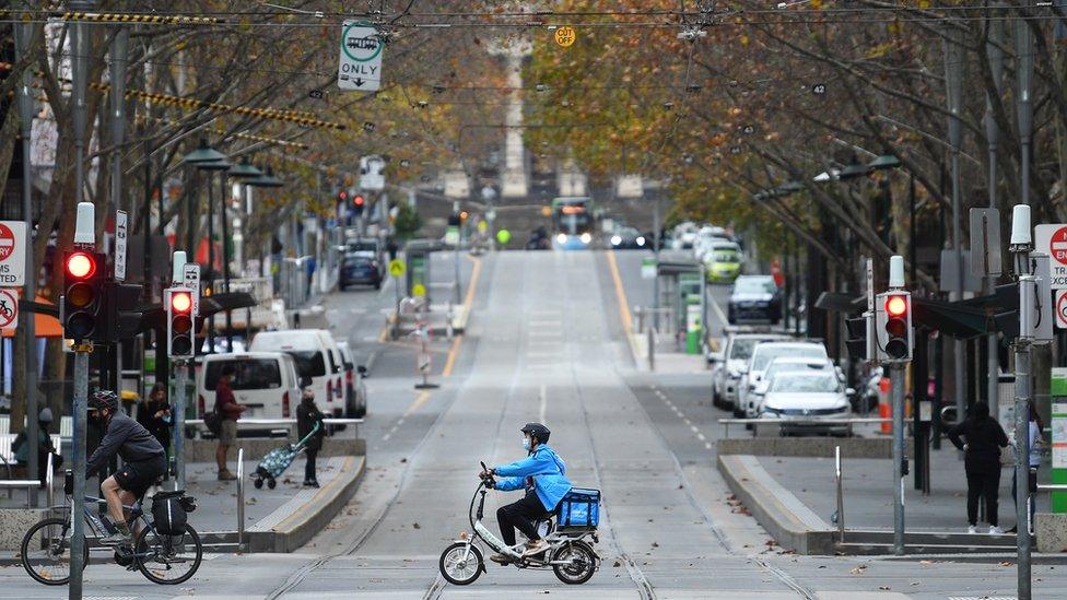 A food delivery driver drives through the deserted Melbourne city centre