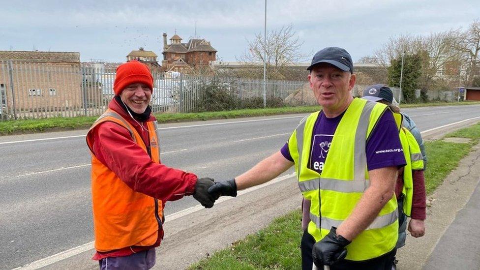 Andy Blacker shakes hands with a passing postman