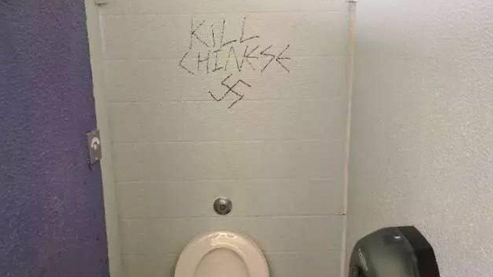 Graffiti on a wall says "kill Chinese" alongside a swastika