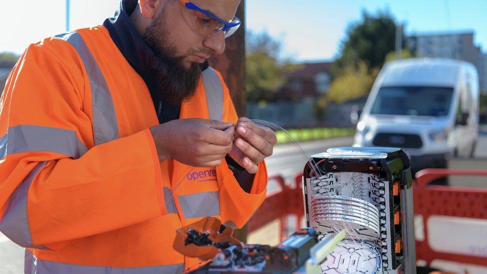 BT engineer handling fibre cables