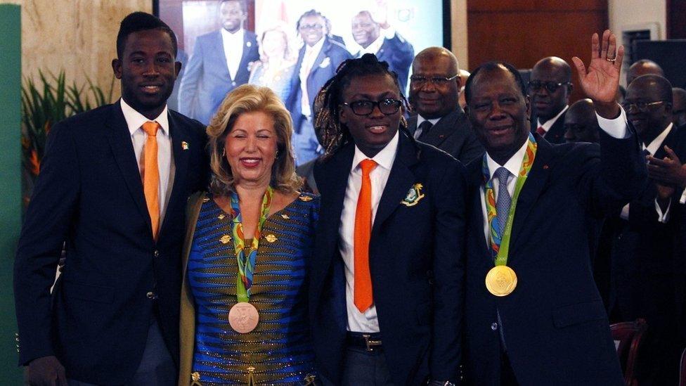 Ivorian President Alassane Ouattara (R) and his wife Dominique Ouattara pose with the Olympians.